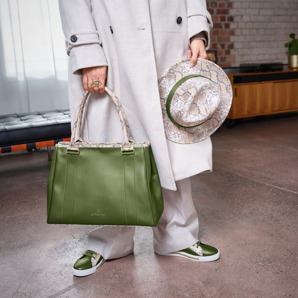 Model mit Handtasche, Sneakern und Hut aus veganem Leder in Oliv und Snake-Optik