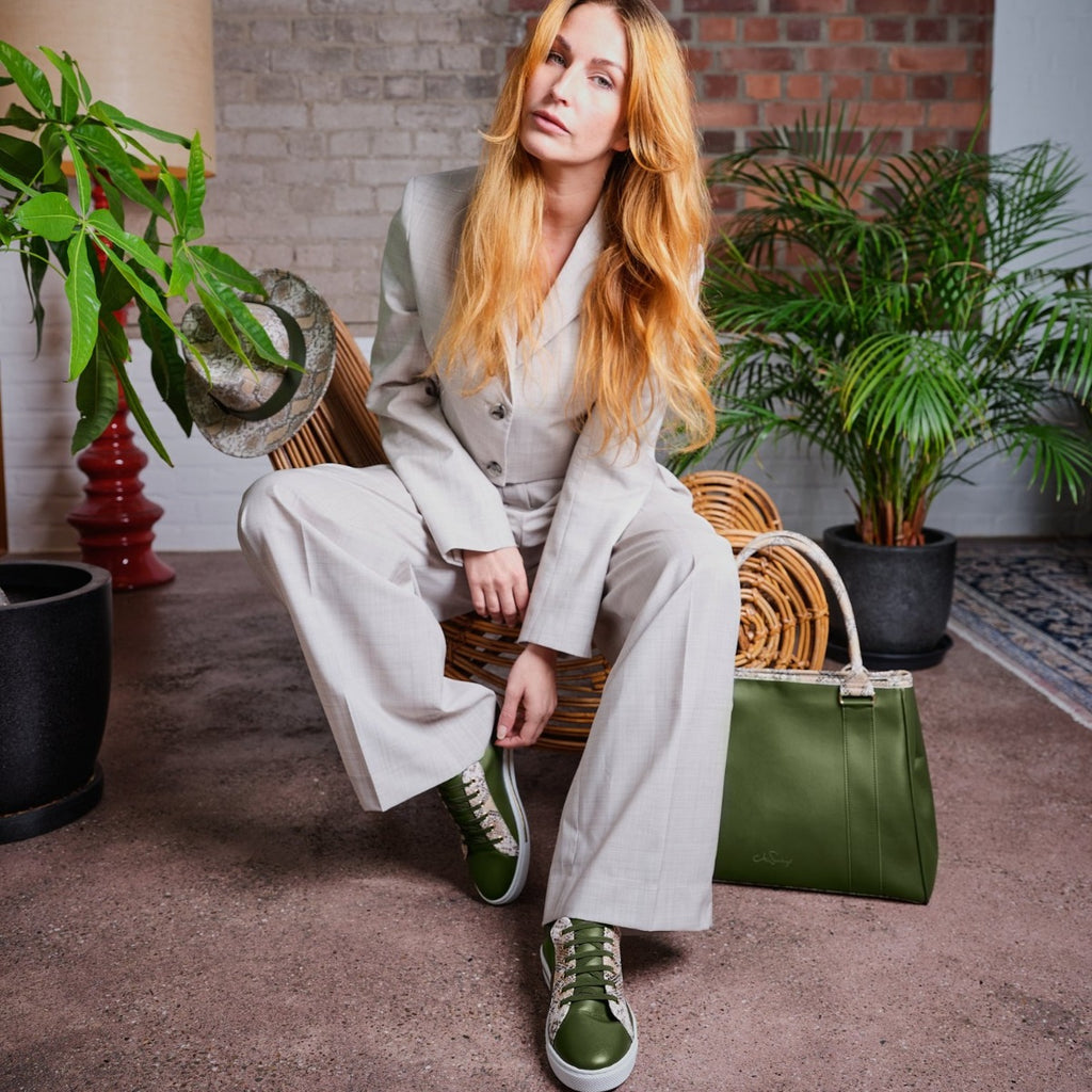 Model mit passender Handtasche, Sneakern und Hut Sneaker aus veganem Leder in Oliv und Snake-Optik