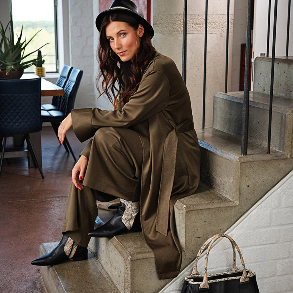 Model mit passender Handtasche, Ankle Boot und Hut aus veganem Leder in Schwarz und Snake-Optik