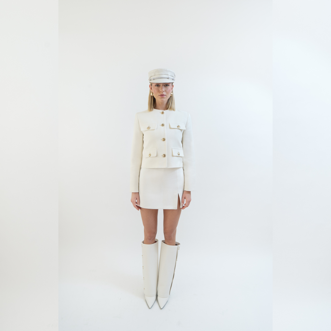 Frau mit cremefarbenem Kostüm mit den Yve Boots und Bakerboy Cap in creme