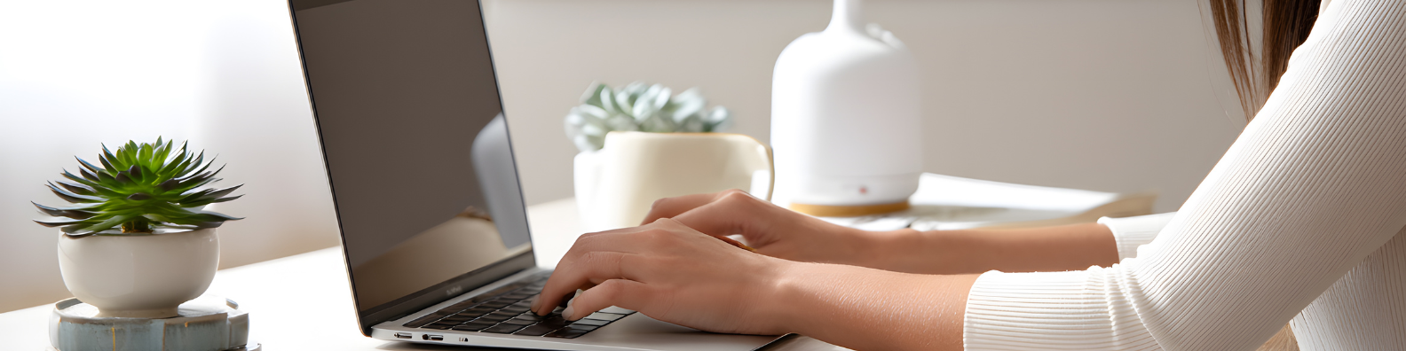 Frau am Schreibtisch tippt auf dem Laptop